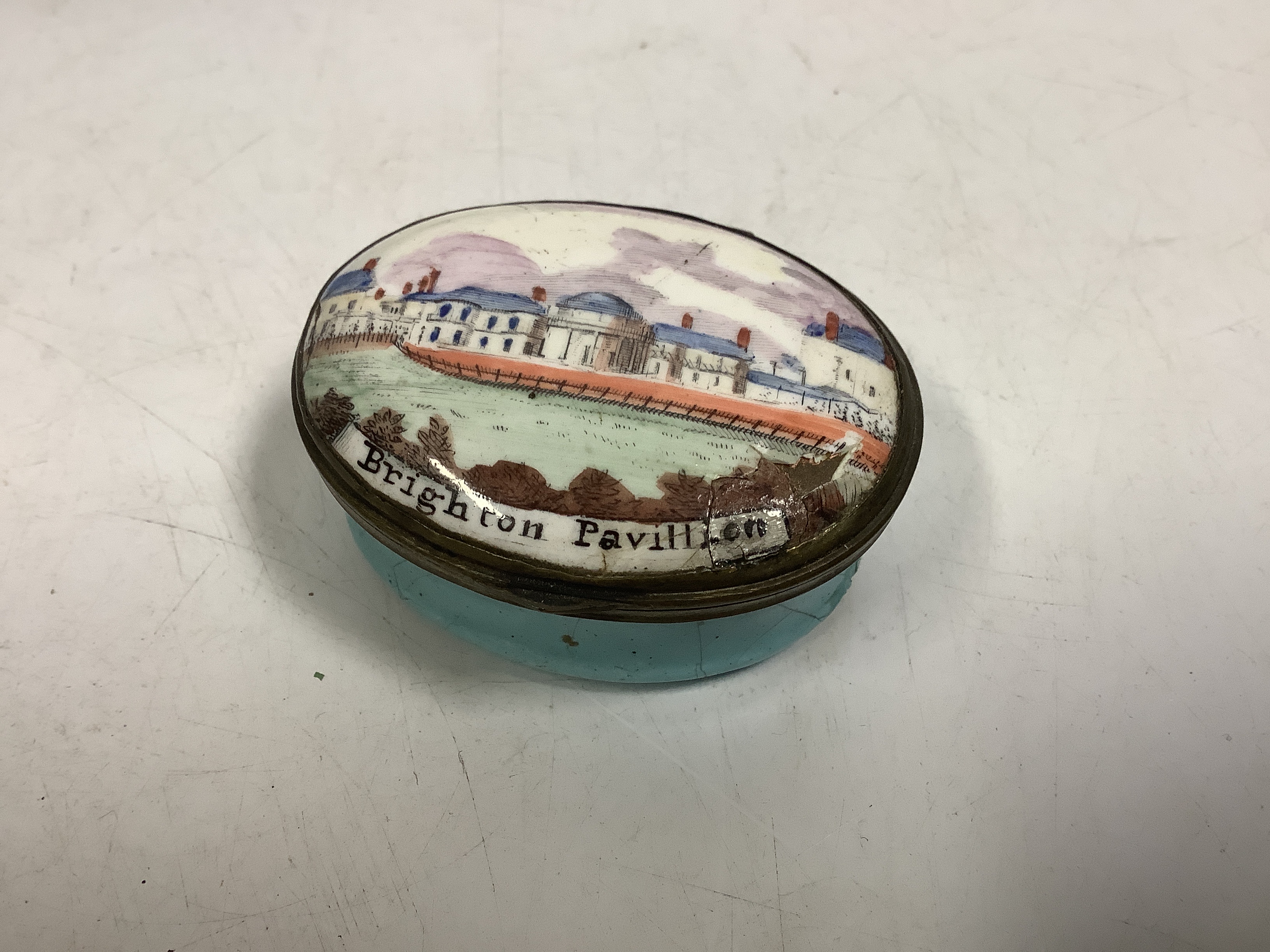 A rare South Staffordshire enamel patch box with an early view of Henry Holland’s Brighton pavilion, c.1800, 5 cm across, a/f